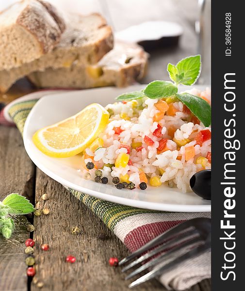 Rice, vegetables and bread on a wooden table