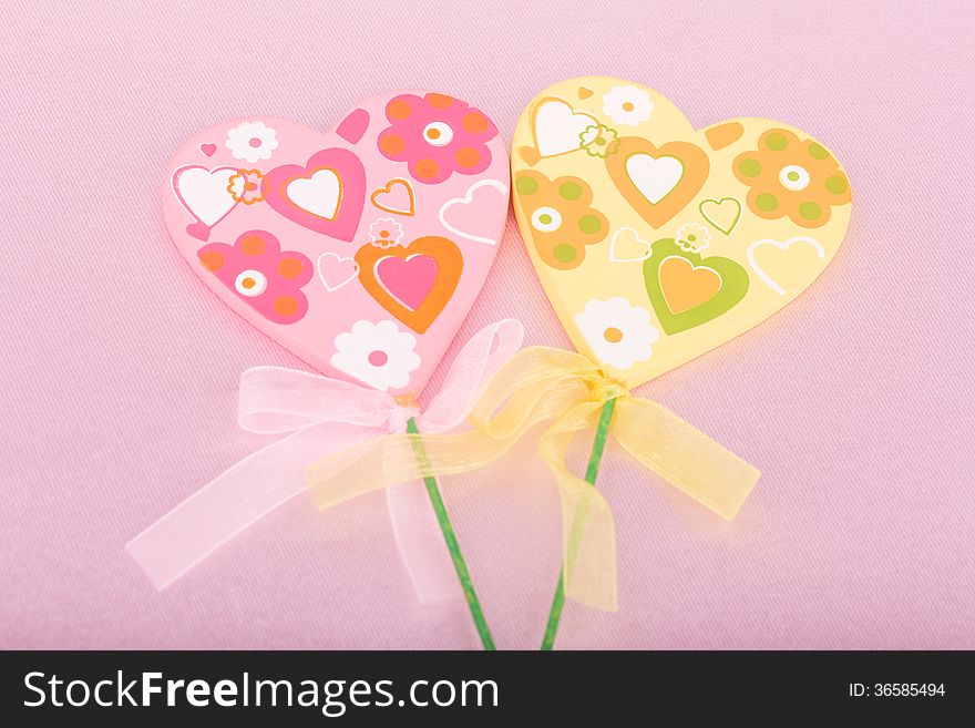 Pink and yellow handmade hearts over pink background