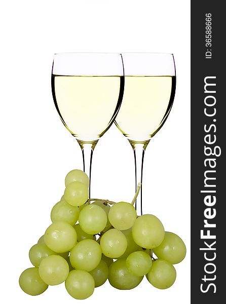 Glasses of white wine and grapes on a white background. Glasses of white wine and grapes on a white background