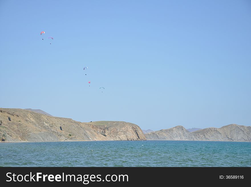 Paragliders against the sea and mountains