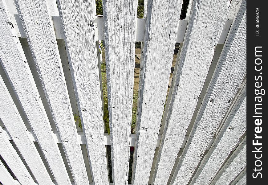 Look down perspective of white wood palisade in sunny day. Look down perspective of white wood palisade in sunny day