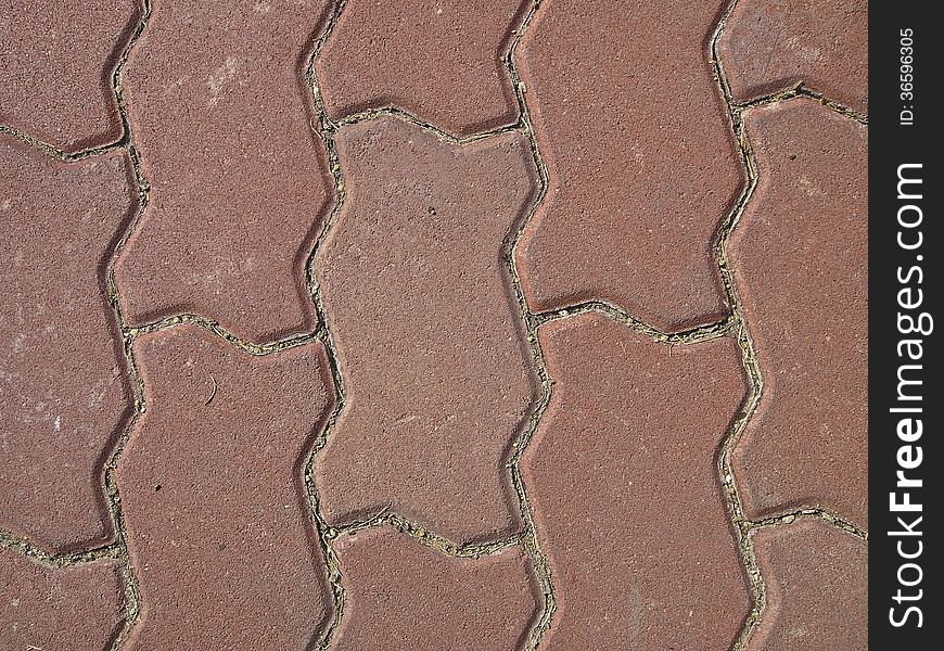 Closeup detail of red cobblestone floor of park in sunlight. Closeup detail of red cobblestone floor of park in sunlight