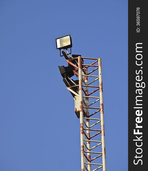 Halogen floodlight on top of pole in sunny day. Halogen floodlight on top of pole in sunny day