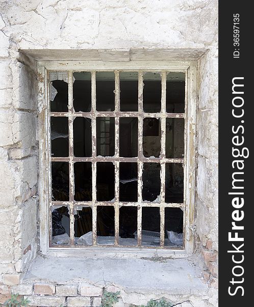 Broken window with bars in a historic building