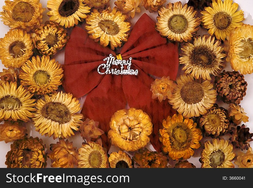 Red christmas bow over yellow flowers background. Red christmas bow over yellow flowers background