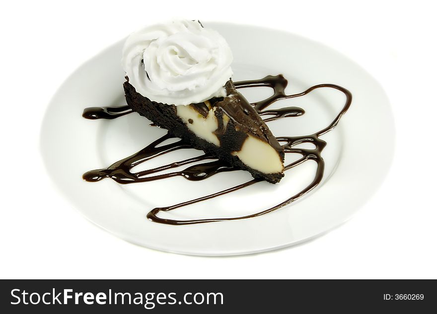 Cheesecake with chocolate sauce and whipped cream isolated on white.