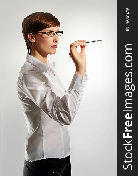Young business woman wearing glasses, holding up pen