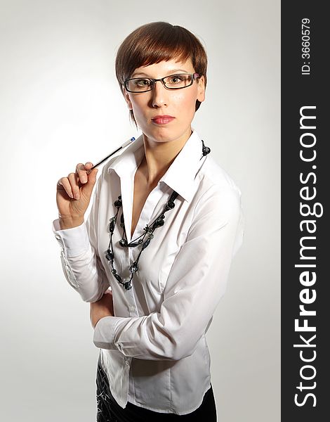 Young business woman wearing glasses, holding pen. Young business woman wearing glasses, holding pen