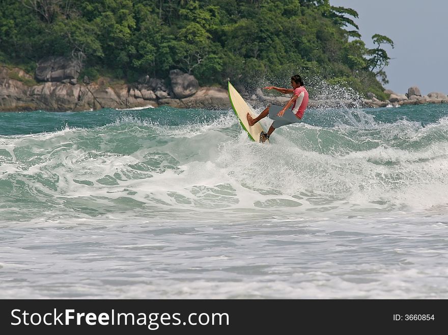 A local surfer tucks into a hollow wave on a beach in Phuket, Thailand. A local surfer tucks into a hollow wave on a beach in Phuket, Thailand