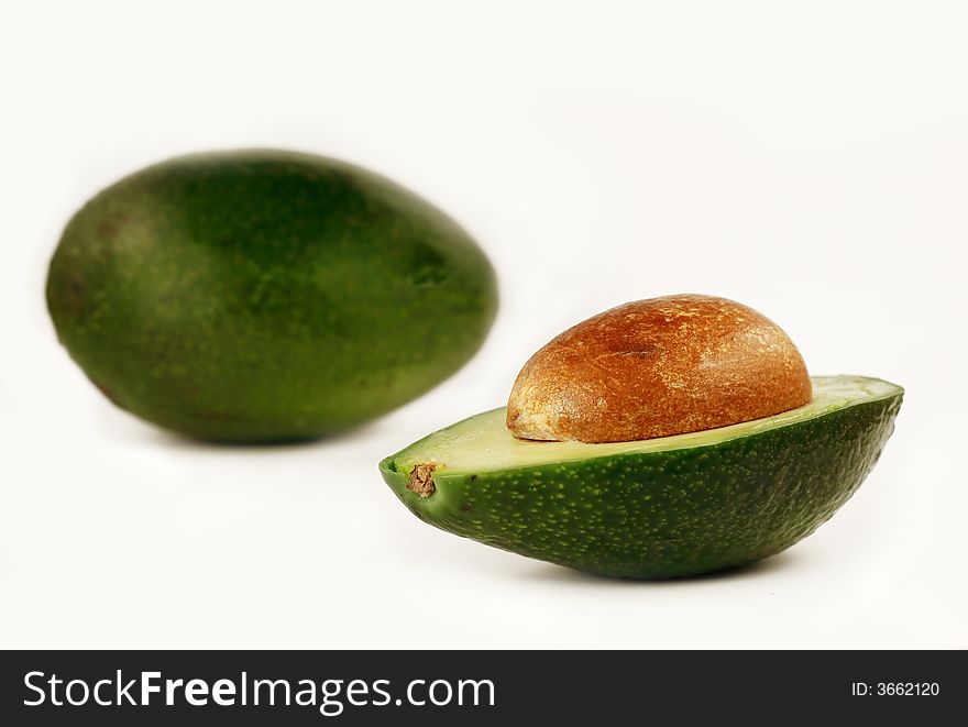 Whole and half avocado isolated on white