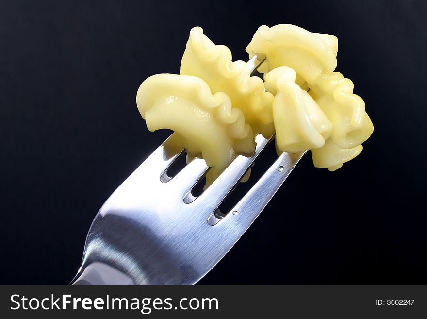 PASTA ON FORK ON BLACK BACKGROUND