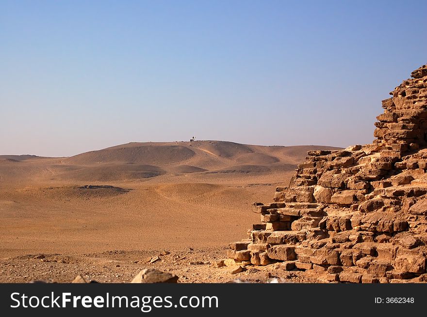 Dunes, sand, stones and camel in Egypt desert