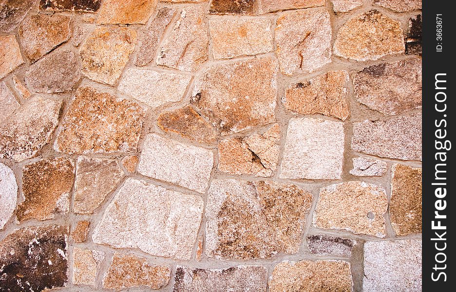 A granite stone wall of brightly colored  blocks. A granite stone wall of brightly colored  blocks