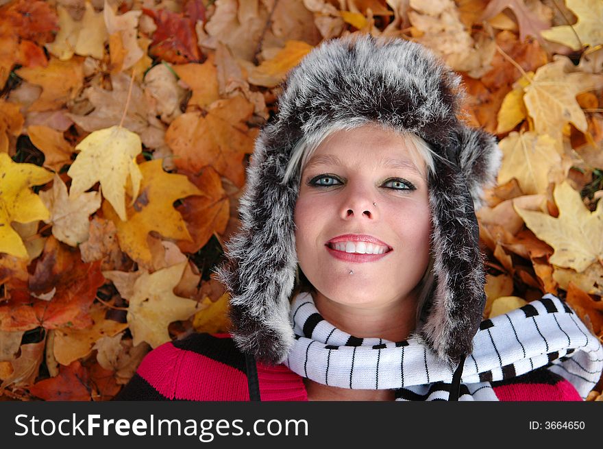 Portrait of girl lying with colorful leaves
