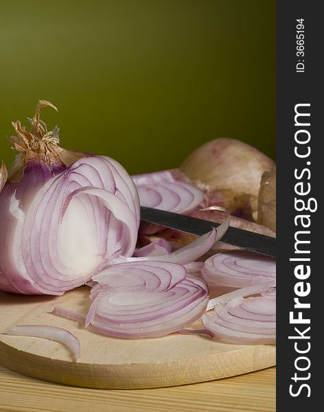 Onion on wooden cutting board with knife. Onion on wooden cutting board with knife.