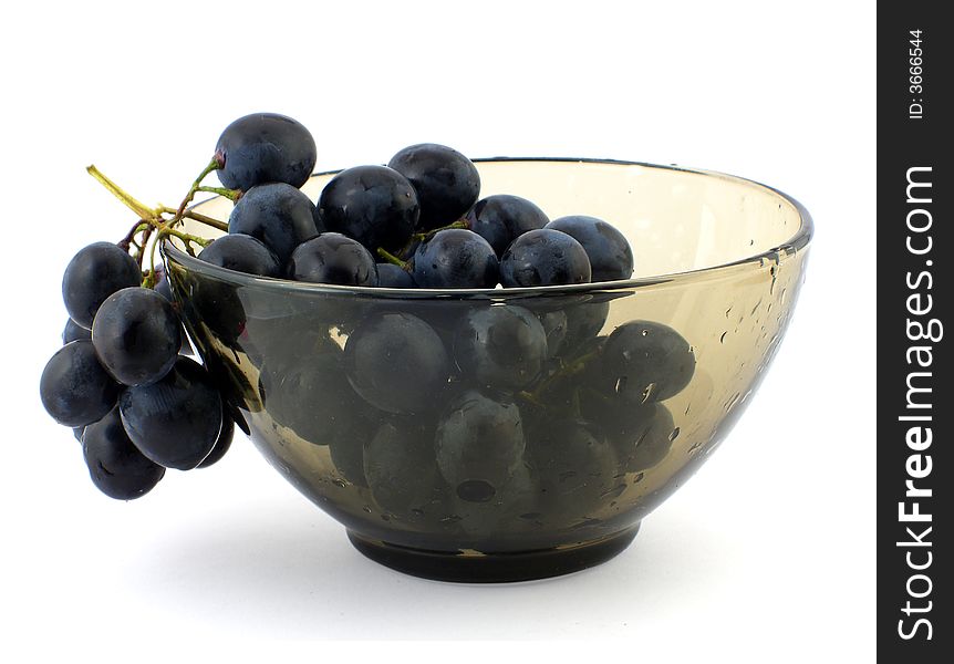 Cluster of grapes in wet glass bowl, isolated on white. Cluster of grapes in wet glass bowl, isolated on white.