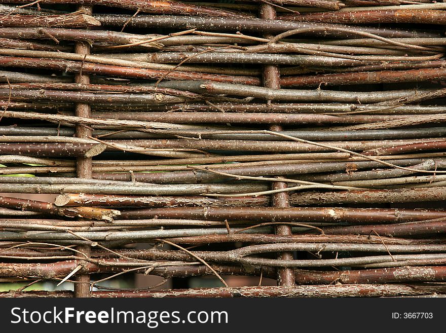 Woven wooden willow fencing in horizontal lines.