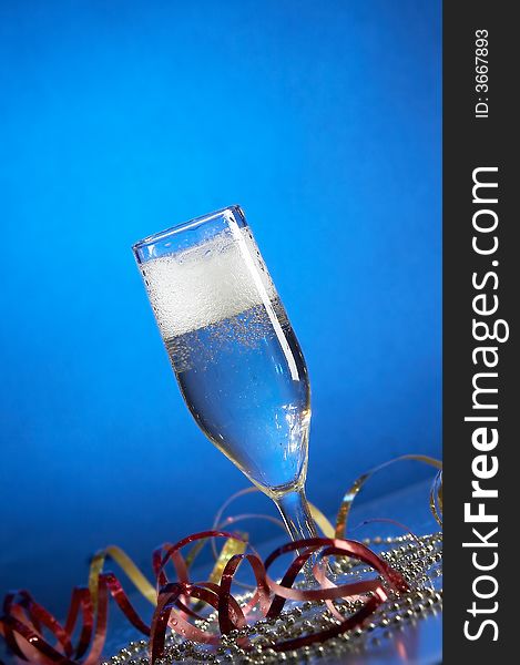 Still life with glass with champagne on the blue background