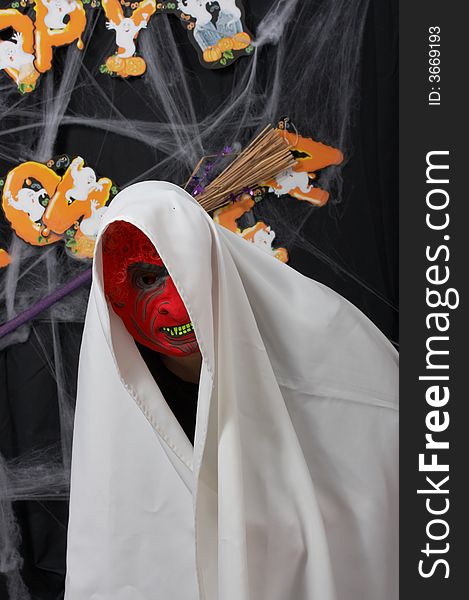 A man wearing a scary mask over a halloween background