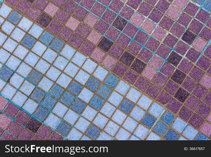 Old mosaic tiles of different shades lined with diagonal blue pattern. Old mosaic tiles of different shades lined with diagonal blue pattern