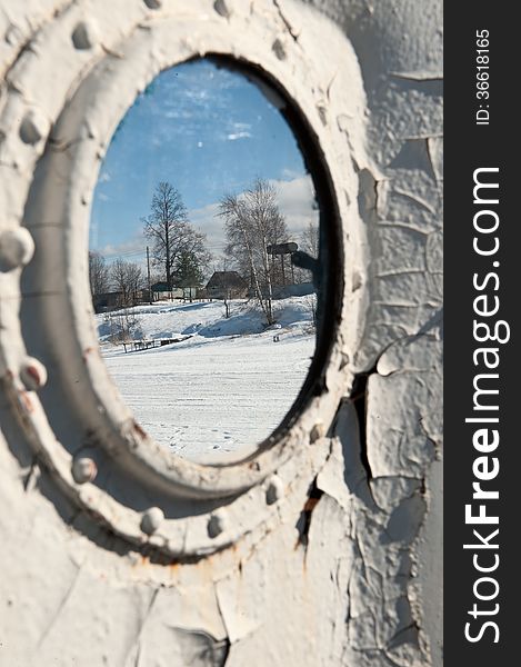 Frozen porthole on the white ships wall with landscape. Frozen porthole on the white ships wall with landscape