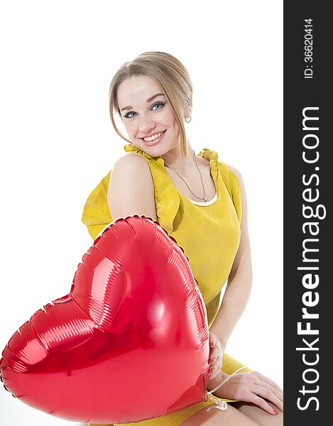 Smiling woman with red heart balloon on white background