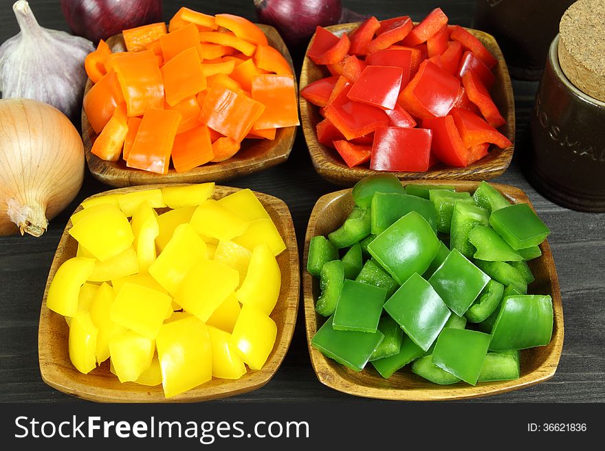 Colorful diced peppers in a wooden bowls