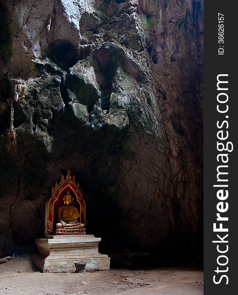 A Sitting Golden Buddha in the caveg at Khao Luang Cave Temple in Petchaburi, Thailand. A Sitting Golden Buddha in the caveg at Khao Luang Cave Temple in Petchaburi, Thailand