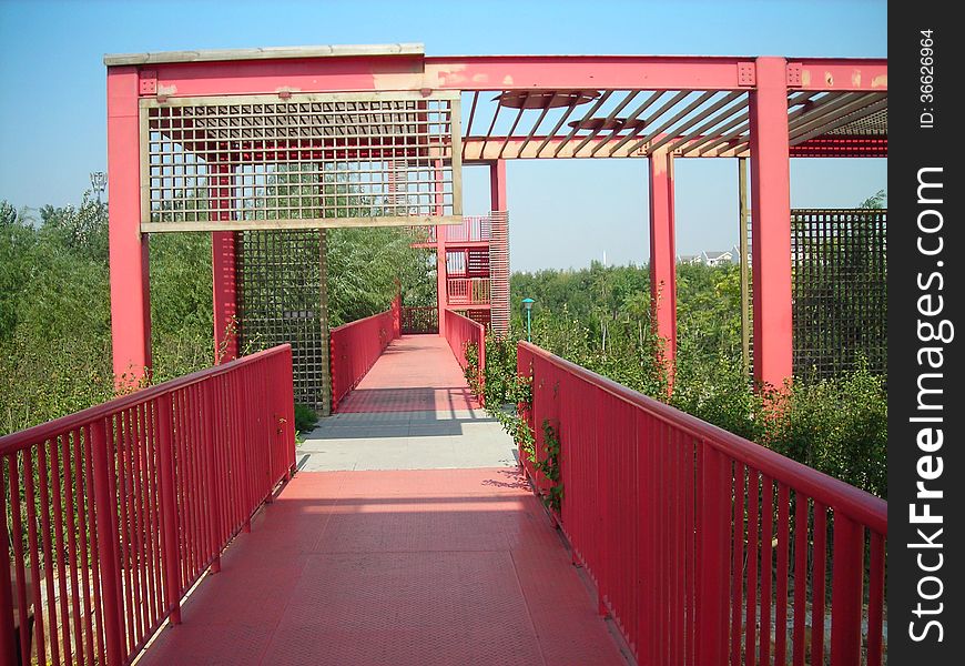 red iron bridge in city green field