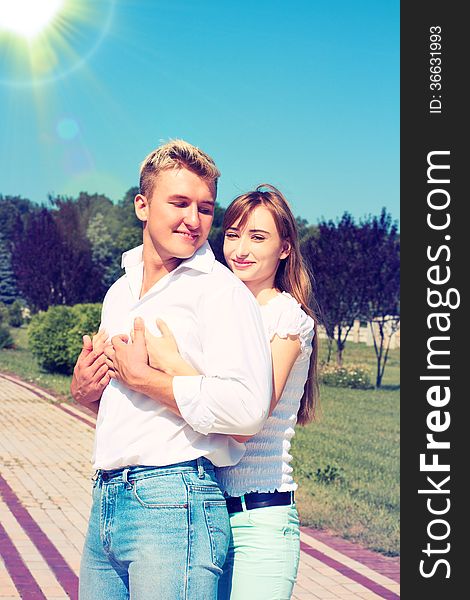 Portrait of Beautiful Young Couple in Love on nature. Man and Woman Smiling Charmingly. Young Couple Kissing Summer on Sunny Sky Background. Portrait of Beautiful Young Couple in Love on nature. Man and Woman Smiling Charmingly. Young Couple Kissing Summer on Sunny Sky Background