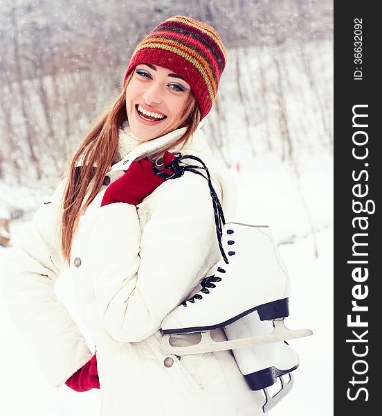 Beautiful young woman smiling happily. Winter activities at the rink with skates