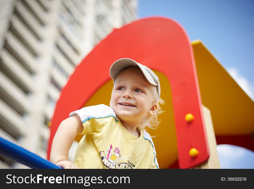 The child looks into the distance from a height of slides