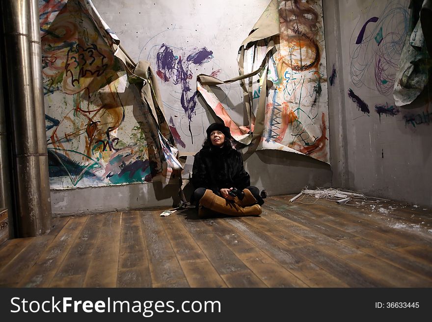 Apartment to let. Marture woman sitting on floor in old deserted apartment