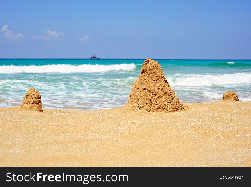 Sea ​​shore with towers of sand on a bright sunny day. Sea ​​shore with towers of sand on a bright sunny day