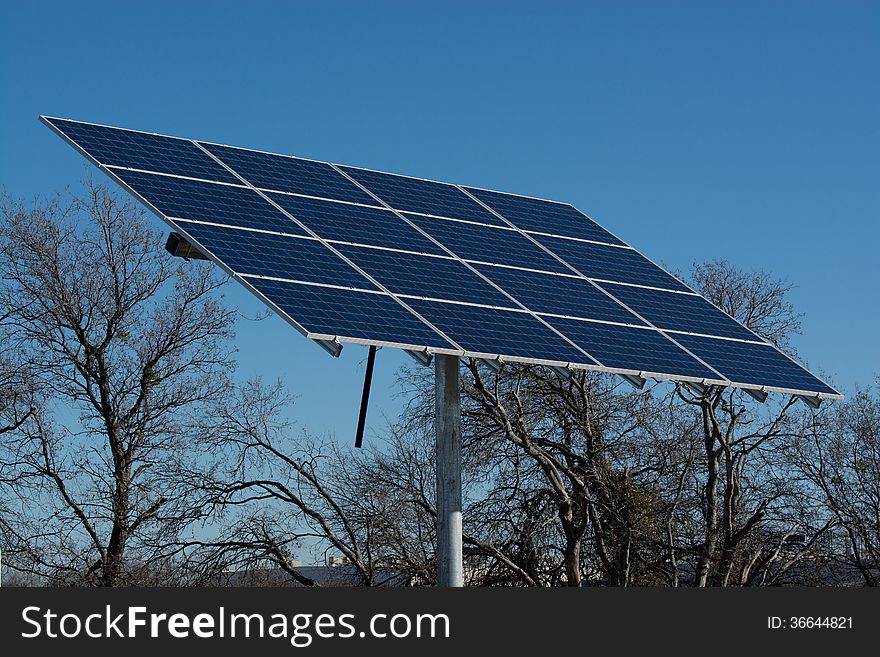 Solar panel grid array in a field with a blue sky. Solar panel grid array in a field with a blue sky