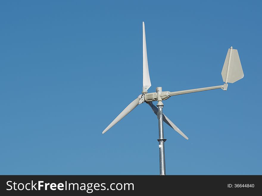A lone wind turbine against a blue sky. A lone wind turbine against a blue sky