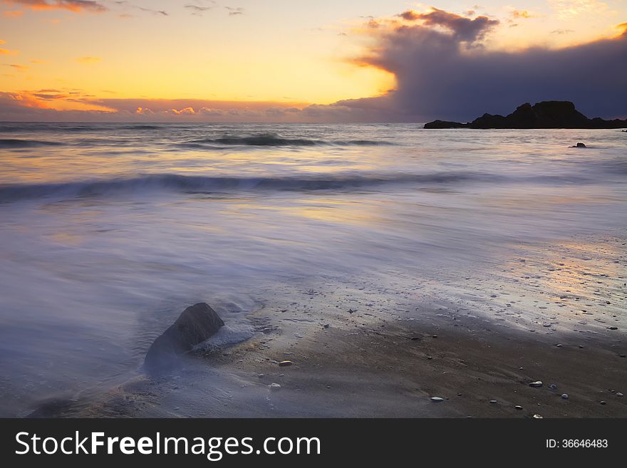 Long exposure time blurs incoming tide at sunset. Long exposure time blurs incoming tide at sunset