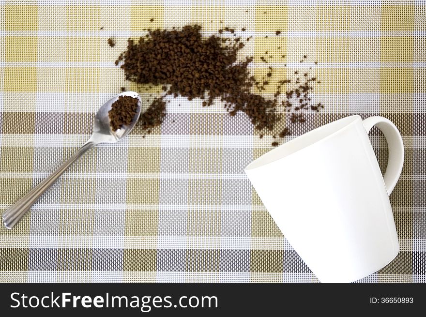 Instant coffee in spoon and splash out of cup. Instant coffee in spoon and splash out of cup