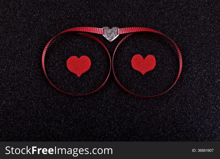 Hearts and red ribbon on black ceramic background. Hearts and red ribbon on black ceramic background