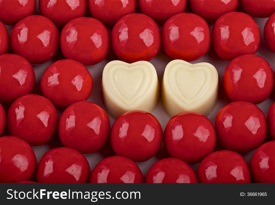 Valentines Day red candies and two hearts with white chocolate. Valentines Day red candies and two hearts with white chocolate