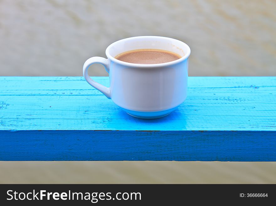 Hot coffee in white cup on wooden, During leisure time on river background