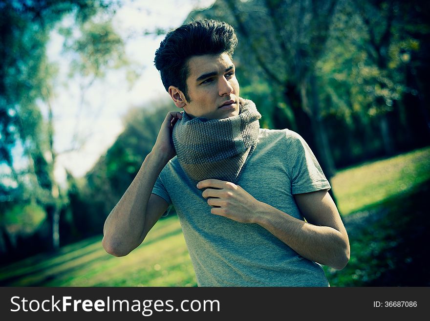 Attractive young handsome man, model of fashion in the park