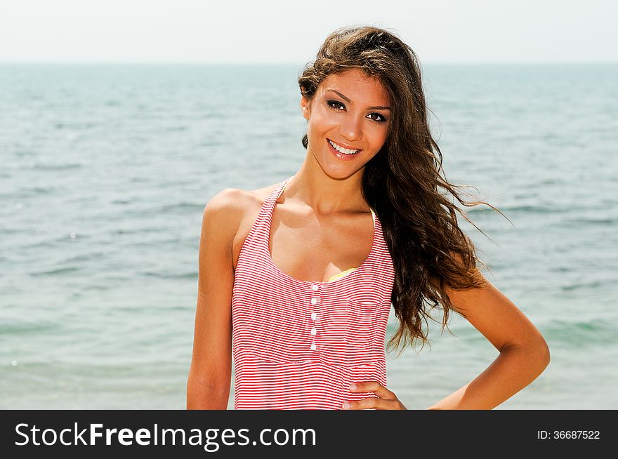 Beautiful woman with long pink dress on a tropical beach