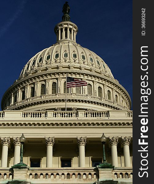 The dome of the U.S. Capitol in Washington, D.C., with the American flag flying in the wind. The dome of the U.S. Capitol in Washington, D.C., with the American flag flying in the wind.