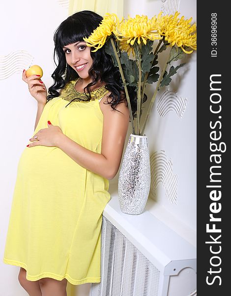 Beautiful pregnant woman with black hair with an apple. Beautiful pregnant woman with black hair with an apple