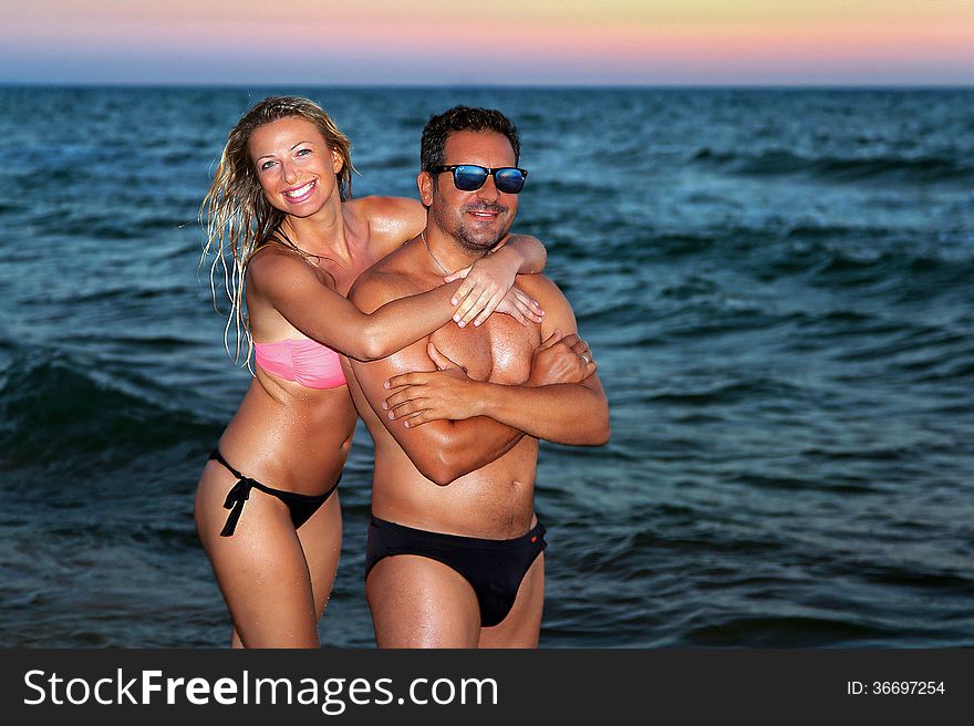 Woman pictured at sunset on the beach and in the sea. Woman pictured at sunset on the beach and in the sea.