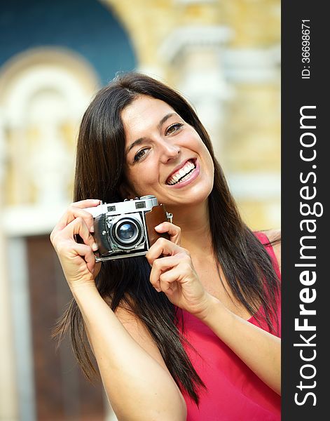 Woman on summer travel taking photo with retro film camera and smiling. Female photographer tourist on european cultural vacation. Woman on summer travel taking photo with retro film camera and smiling. Female photographer tourist on european cultural vacation.