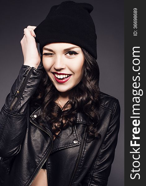 Beautiful girl with black hair in black hat and leather jacket. Beautiful girl with black hair in black hat and leather jacket