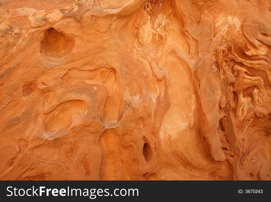 These fascinating patterns were etched into this red sandstone of a slot canyon wall by wind and water.  This is a good background or texture image. These fascinating patterns were etched into this red sandstone of a slot canyon wall by wind and water.  This is a good background or texture image.