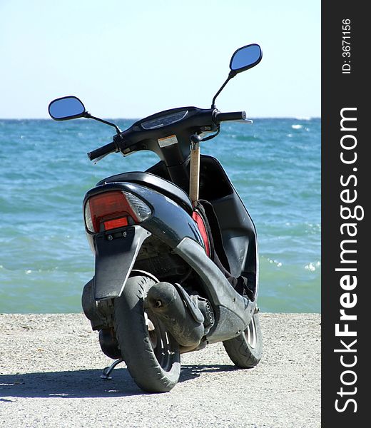 Motorbike on a mooring on a background of the blue sea